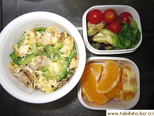 Stirfried pork with bitter melon and egg, sauteed eggplant, lettuce, cherry tomatoes, orange