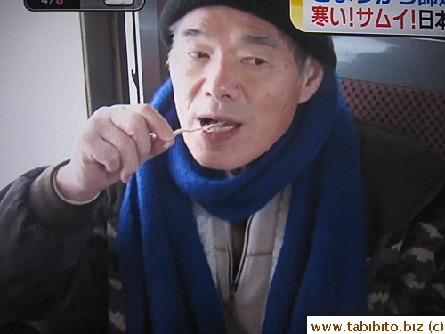 This passenger enjoys the freshly grilled squid and a glass of sake