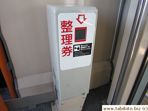 Get on the bus through the mid-door, get a ticket from this machine, hand it to the driver on exit and pay (700Yen/US$8.7)