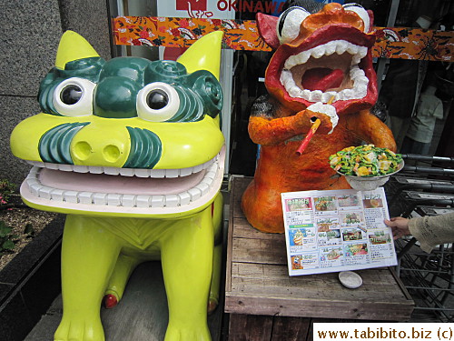 Okinawa Shisa (cross between a lion and a dog) by the entrance, the right one eats the classic Okinawa stirfry dish of bitter melon, Spam, tofu and egg