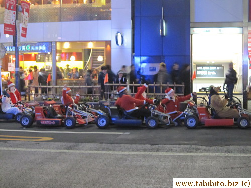 People in Santa suit on a sled on a street in Ginza