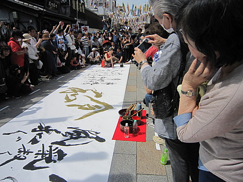 A woman painted Japanese calligraphy on the big piece of paper